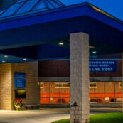 Modern building with blue canopy at night